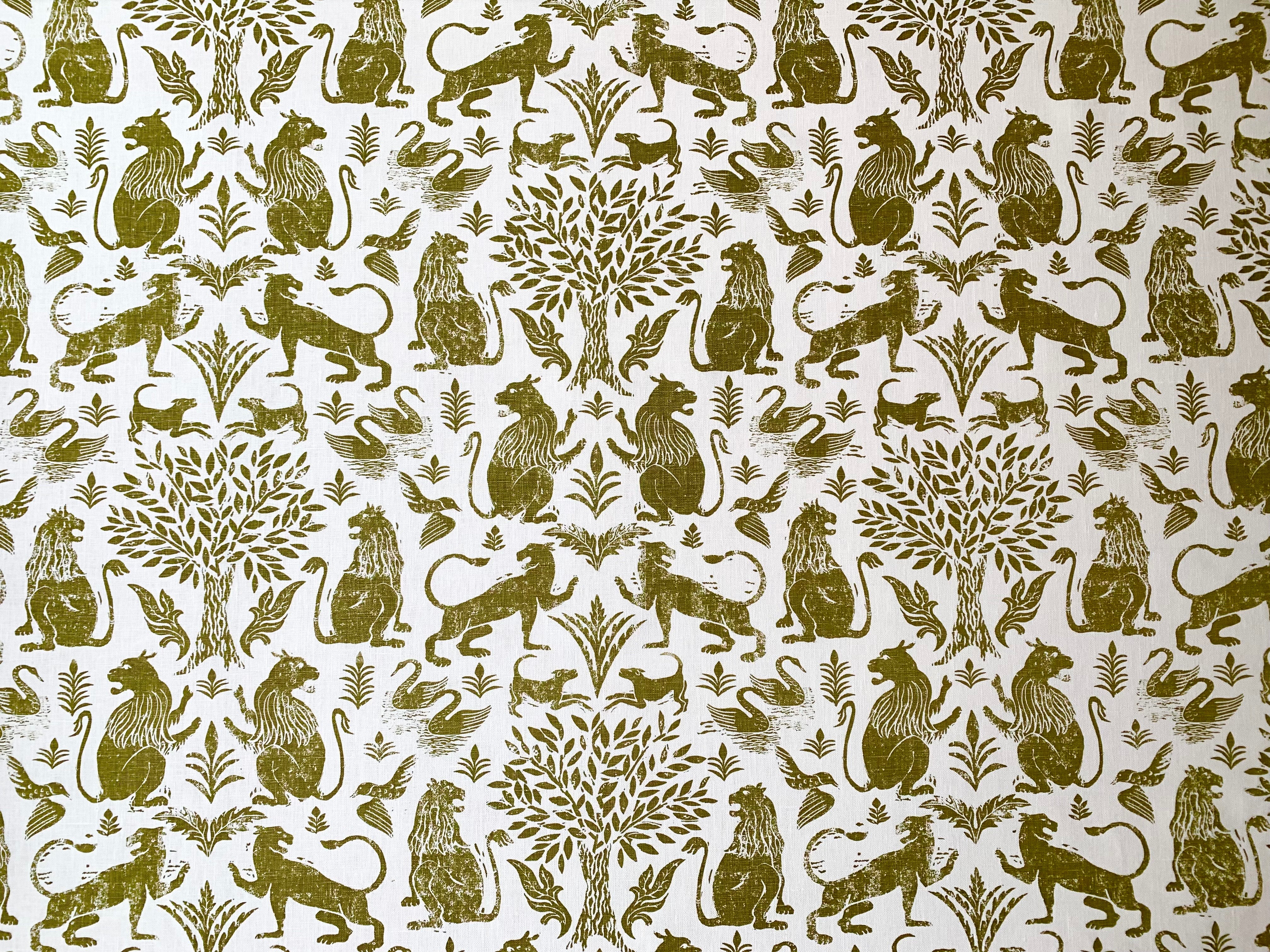 Printed fabric in a lion, mixed animal and plant pattern in olive on a white field.