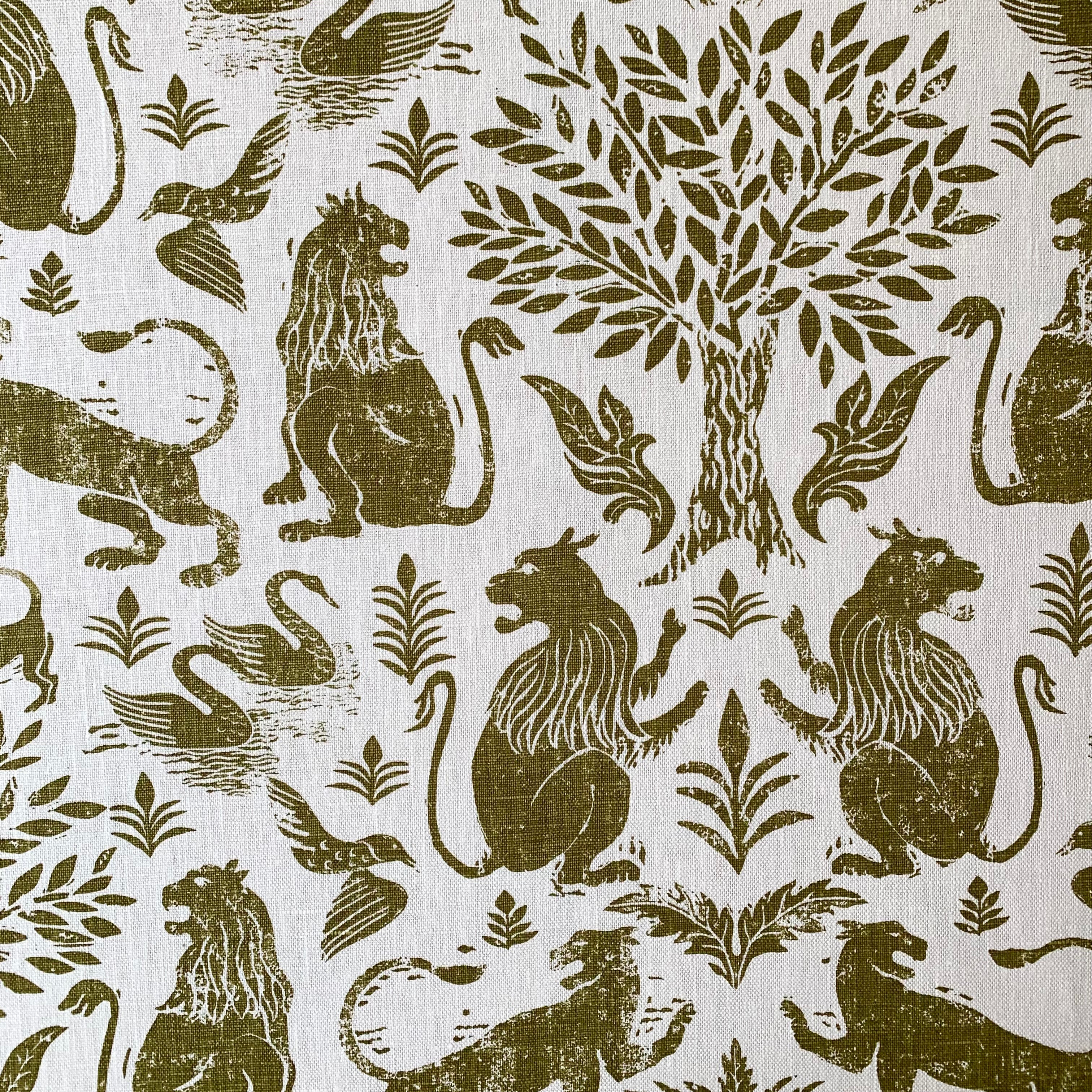 Detail of a printed fabric in a lion, mixed animal and plant pattern in olive on a white field.