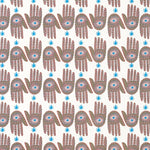 Detail of wallpaper in a playful hamsa hand print in brown, pink and blue on a white field.