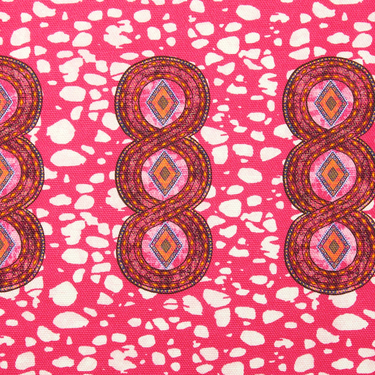 Detail of fabric in an intricate curvilinear print in shades of red, orange and pink.