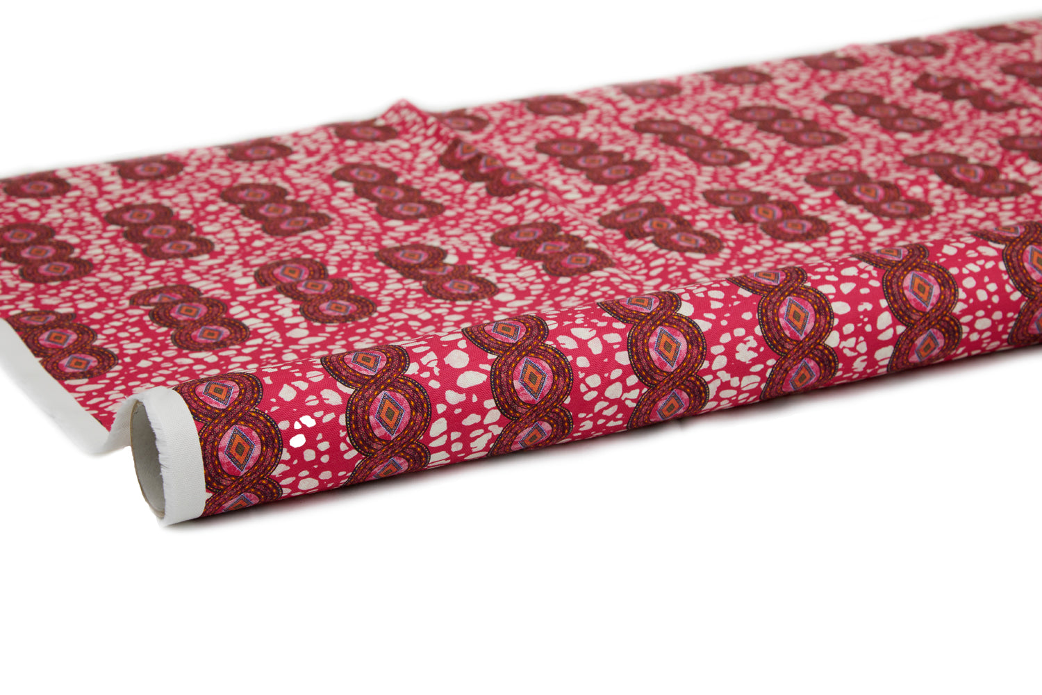 Partially unrolled fabric in an intricate curvilinear print in shades of red, orange and pink.