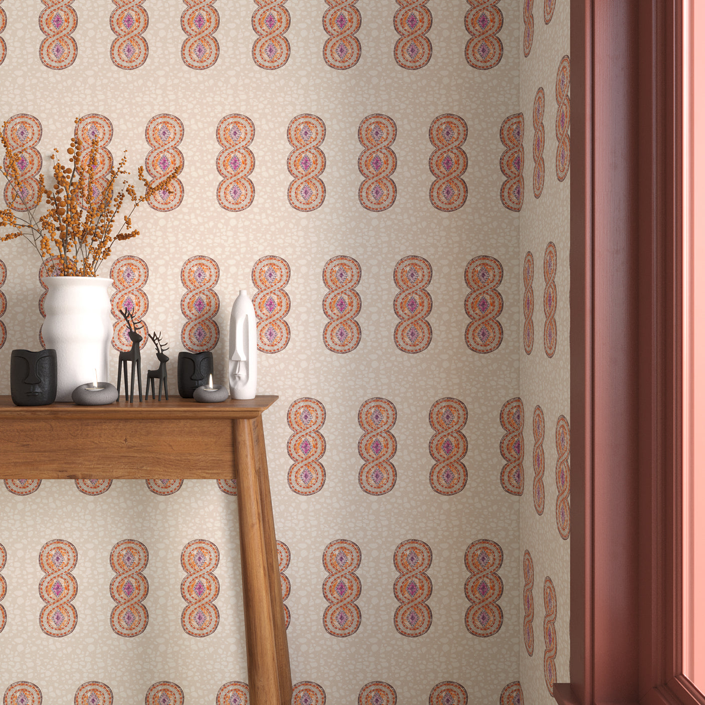 Interior with orange, pink and beige geometric wallpaper and matching trim with a wooden console table with white ceramic vases and mini ceramic sculptures. 