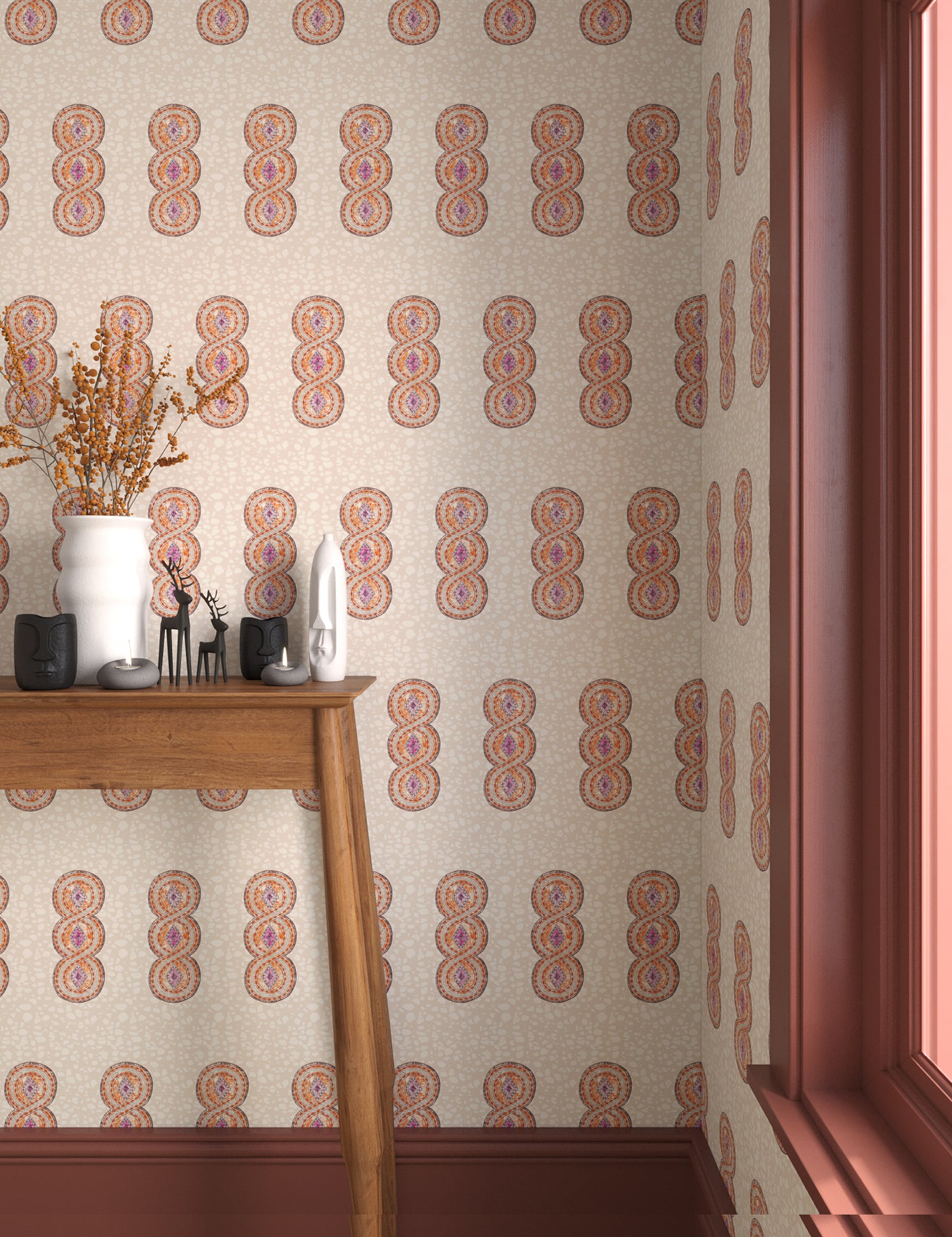 Interior with orange, pink and beige geometric wallpaper and matching trim with a wooden console table with white ceramic vases and mini ceramic sculptures. 