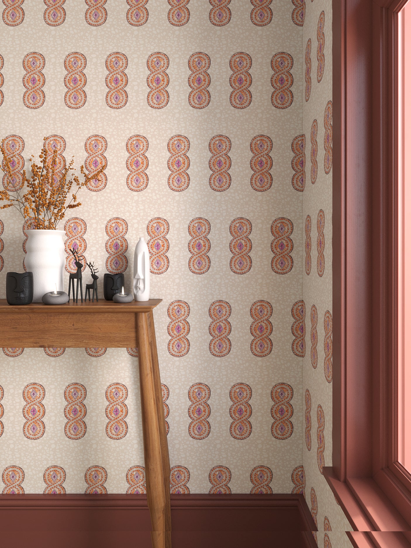 Interior with orange, pink and beige geometric wallpaper and matching trim with a wooden console table with white ceramic vases and mini ceramic sculptures. 