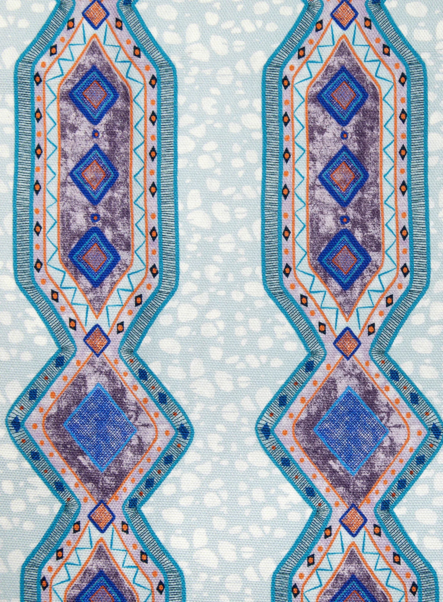 Detail of fabric in a geometric stripe pattern in shades of blue, orange and navy.
