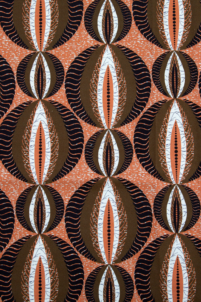 Detail of fabric in an interlocking circular stripe print in shades of orange, brown and black on an orange field.
