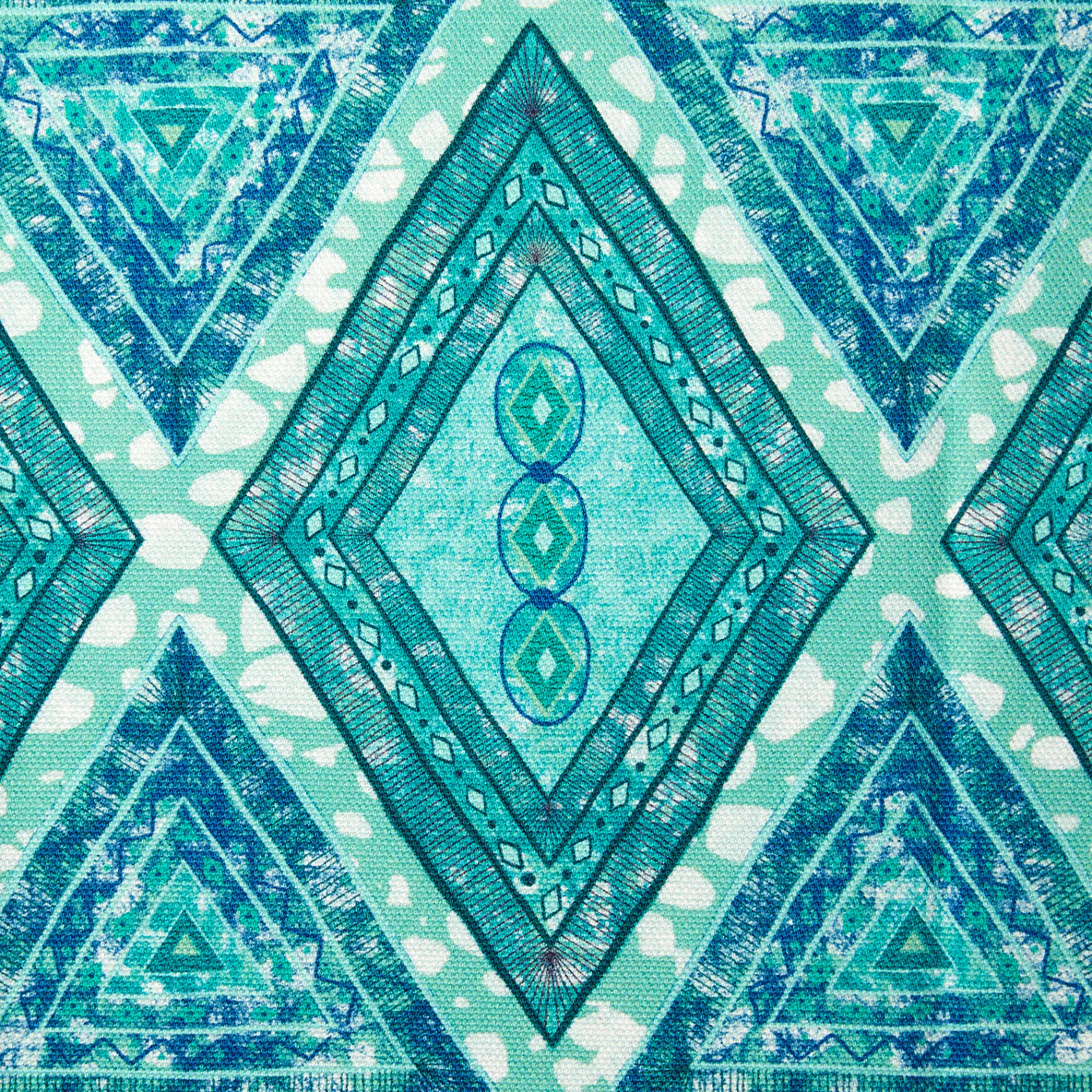 Detail of fabric in an intricate diamond grid pattern in shades of blue and turquoise.