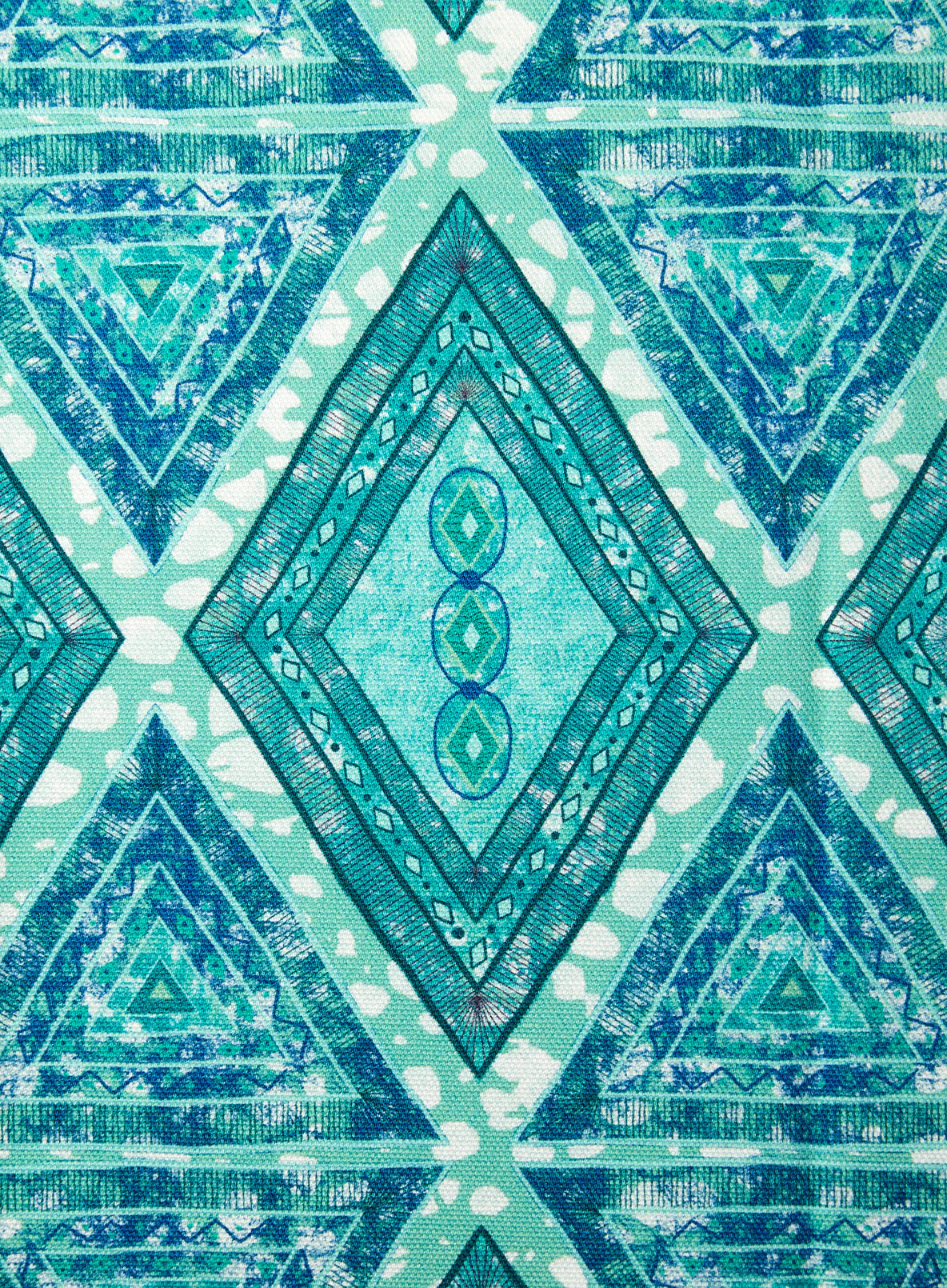 Detail of fabric in an intricate diamond grid pattern in shades of blue and turquoise.