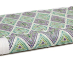 Partially unrolled fabric in an intricate diamond grid pattern in shades of green and purple.