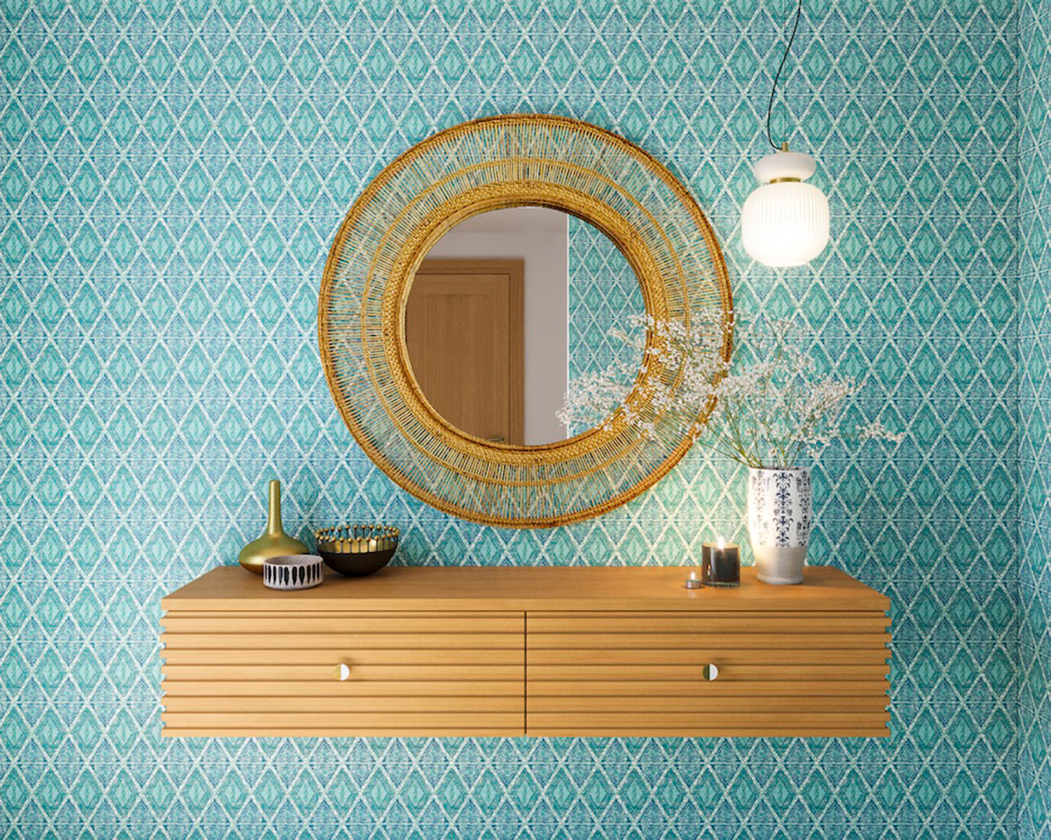 A floating shelf and statement mirror hang on a wall papered in an intricate diamond grid pattern in blue and turquoise.