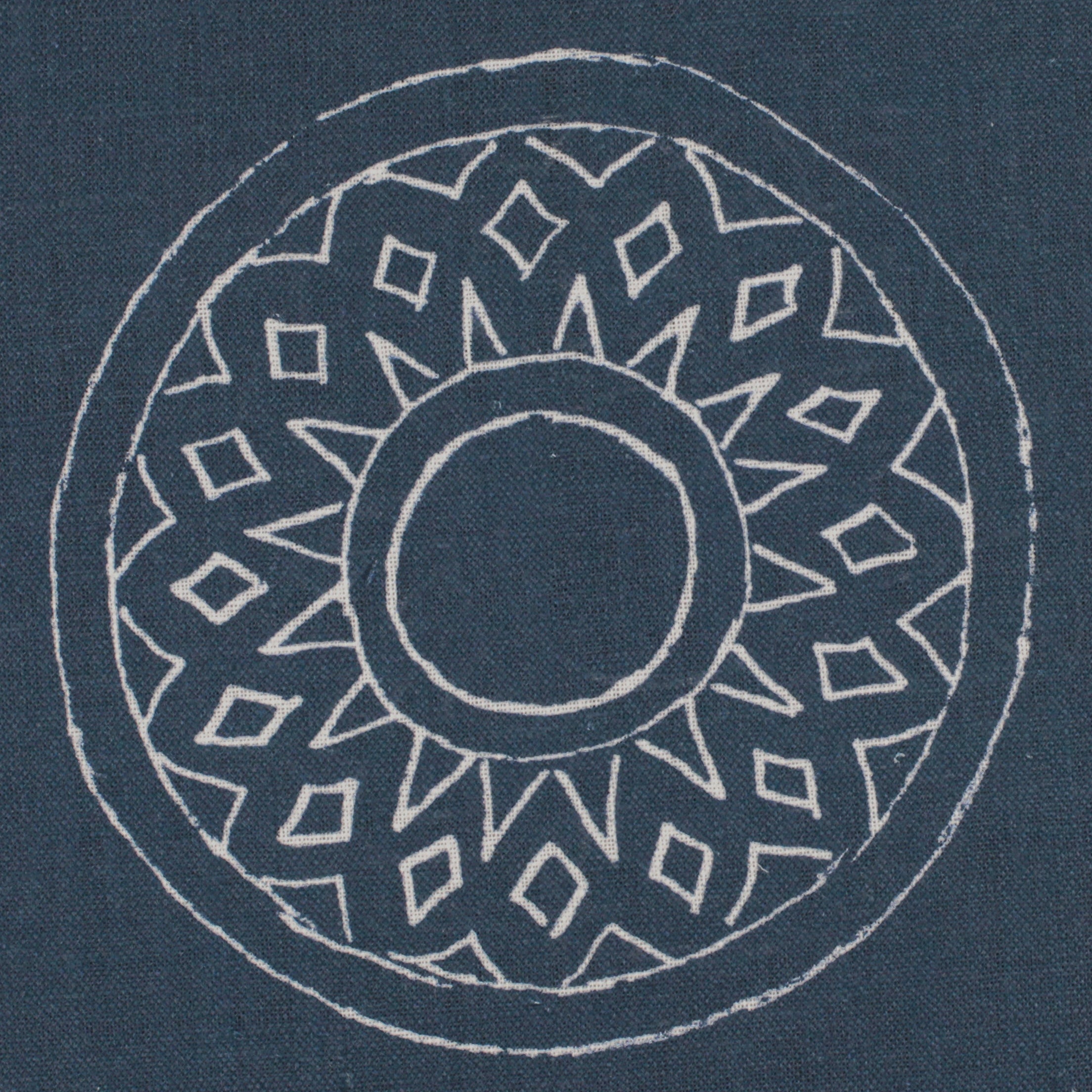 Detail of fabric in a repeating circular geometric print in light gray on a navy field.