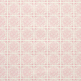 Detail of fabric in a damask lattice print in pink on a cream field.