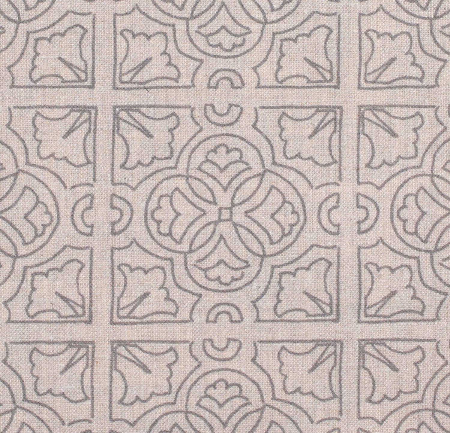 Detail of fabric in a damask lattice print in light gray on a tan field.