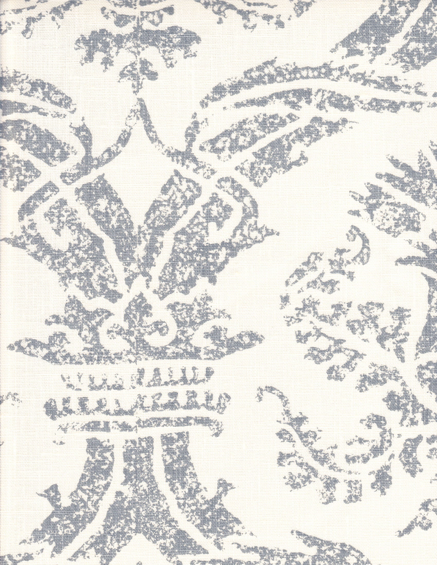 Detail of fabric in a mottled damask print in gray on a cream field.