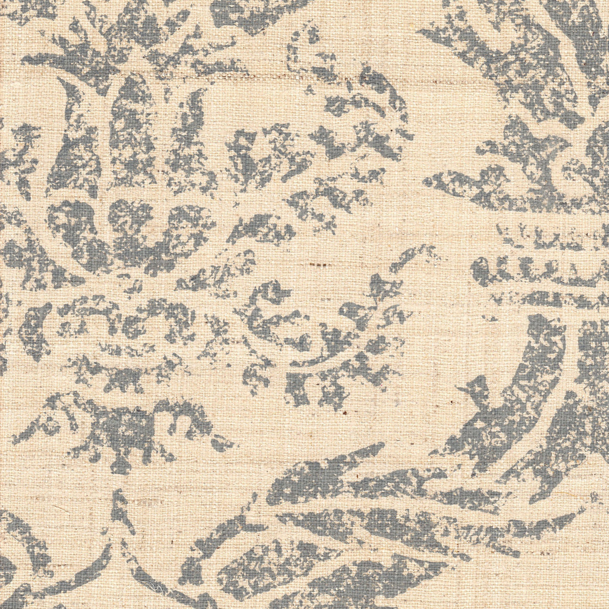 Detail of fabric in a mottled damask print in blue-gray on a cream field.