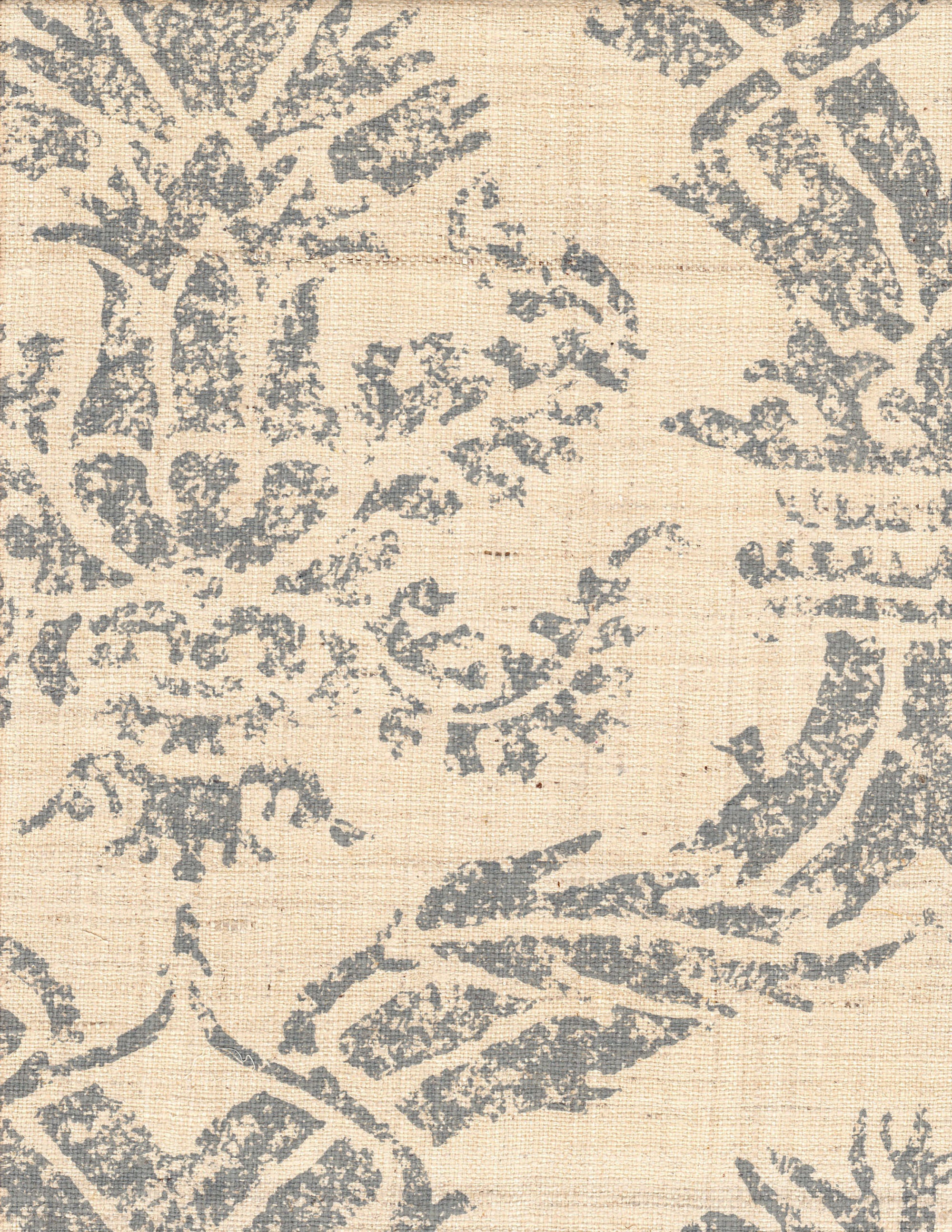 Detail of fabric in a mottled damask print in blue-gray on a cream field.