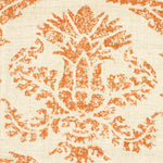 Detail of fabric in a mottled damask print in orange on a cream field.