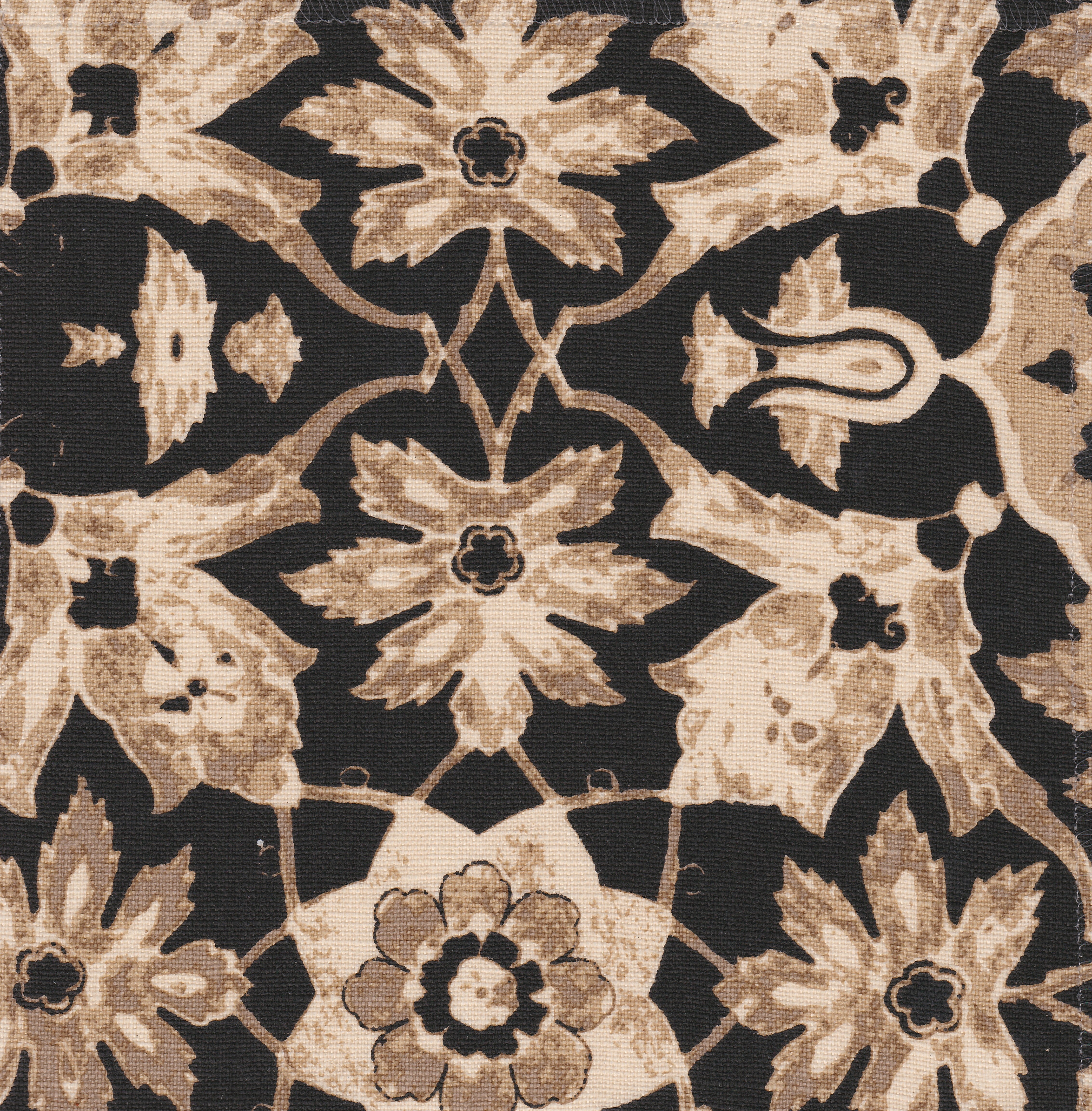 Detail of fabric in a floral damask print in shades of brown and cream on a black field.