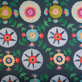 Detail of fabric in a playful floral pattern in a rainbow of colors on a navy field.