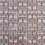 Fabric in a repeating damask print in white and blue on a brown field.