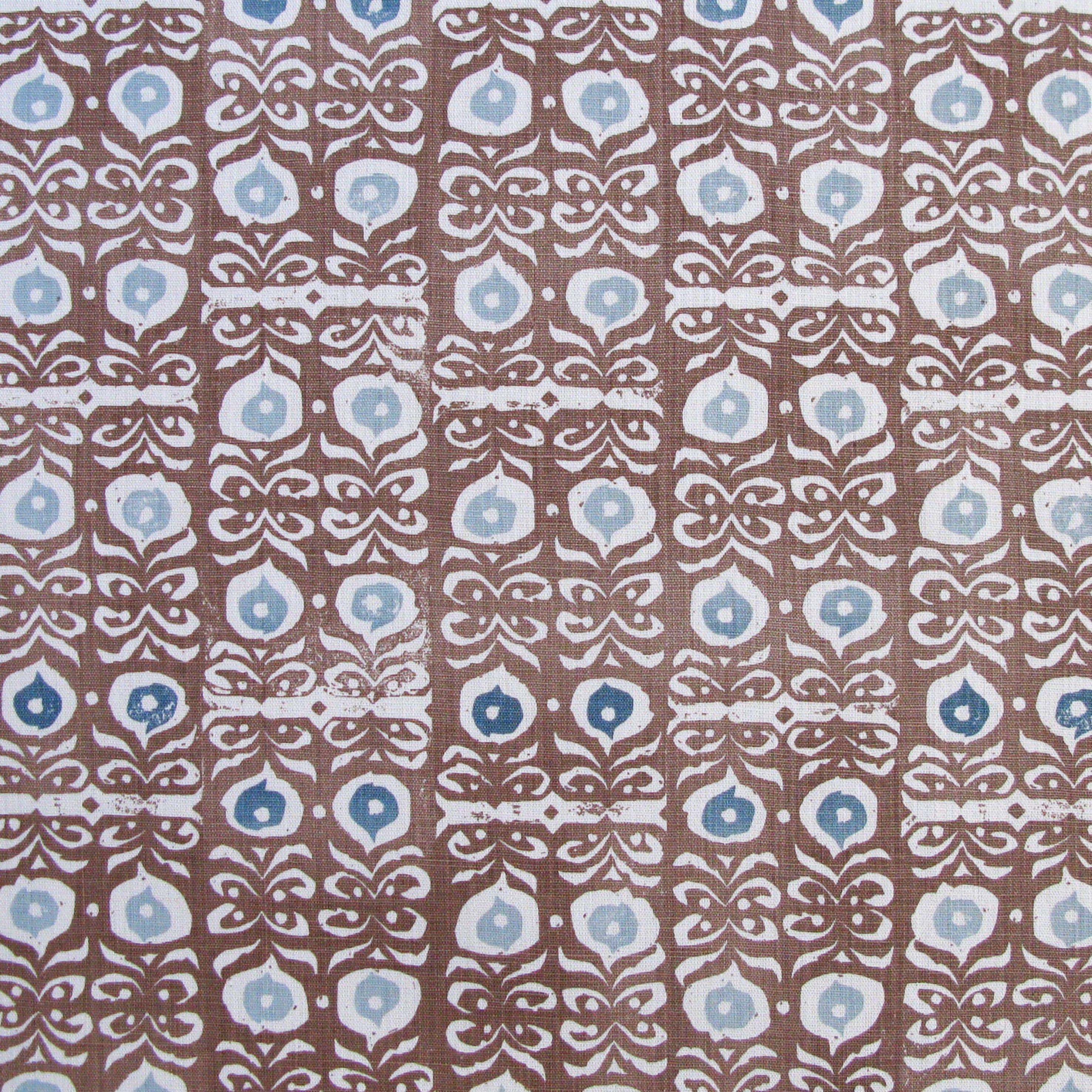 Fabric in a repeating damask print in white and blue on a brown field.