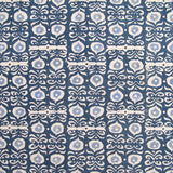 Fabric in a repeating damask print in white and blue on a navy field.