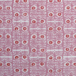 Fabric in a repeating damask print in white and red on a pink field.