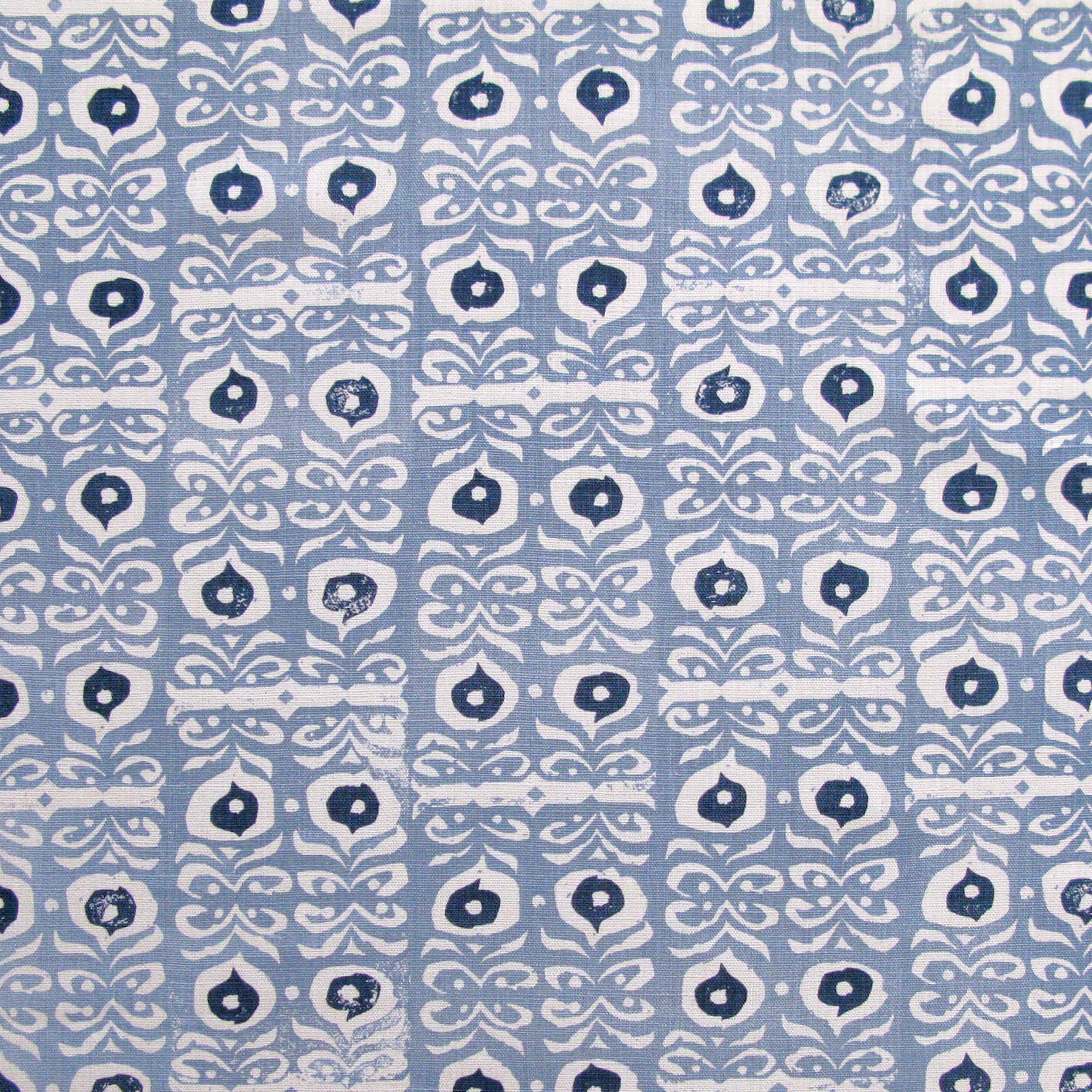 Fabric in a repeating damask print in white and navy on a blue field.