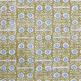 Fabric in a repeating damask print in white and blue on a mustard field.