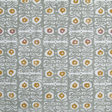 Fabric in a repeating damask print in white and gold on a blue-gray field.