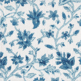 Detail of fabric in a floral damask print in shades of blue and navy on a white field.