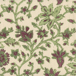 Detail of fabric in a floral damask print in shades of green and purple on a cream field.