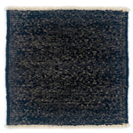 Black textured rug with white border on a white background