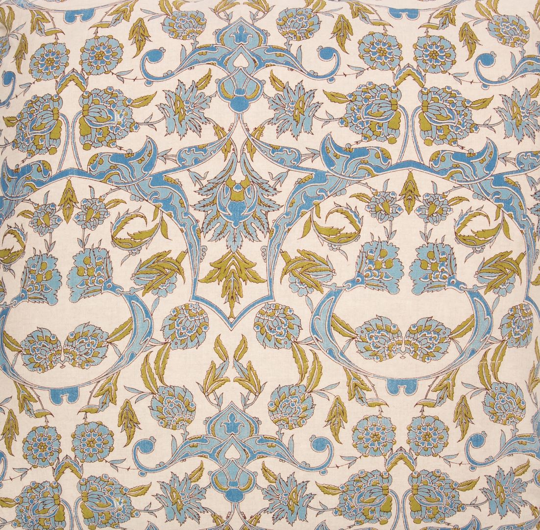 Detail of fabric in a paisley print in blue and mustard on a cream field.