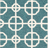 Detail of fabric in a geometric lattice print in white on a dark turquoise field.