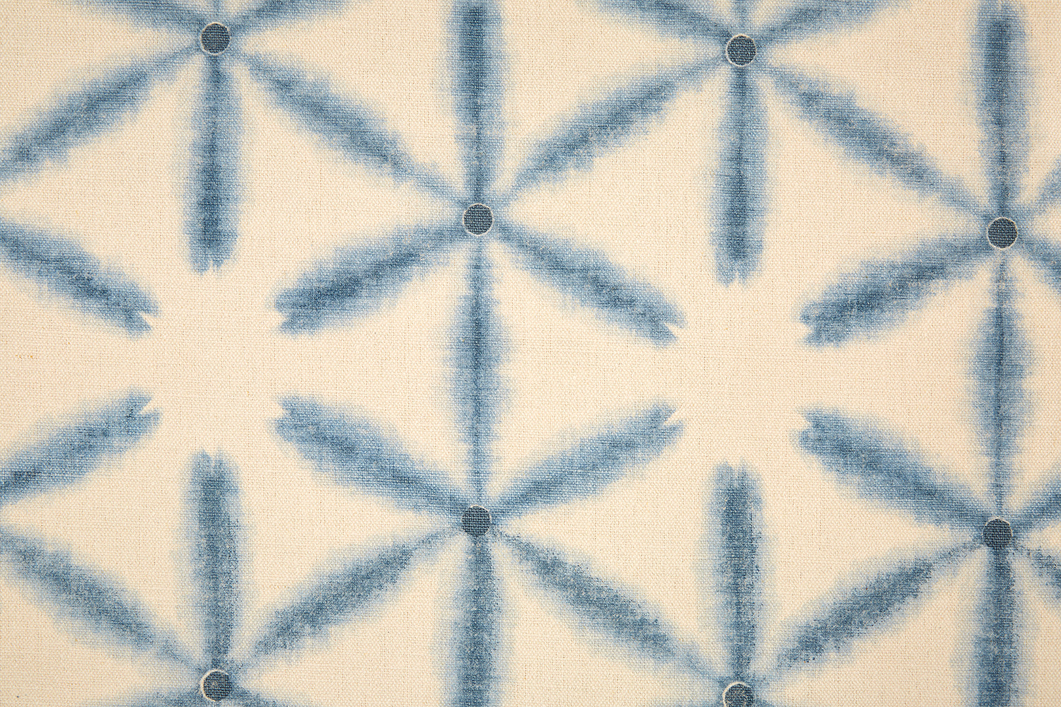 Detail of fabric in a global geometric print in indigo on a cream field.