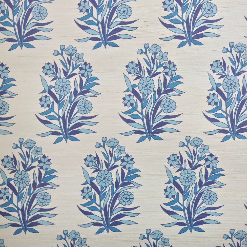 Detail of fabric in a repeating floral print in shades of blue and navy on a tan field.