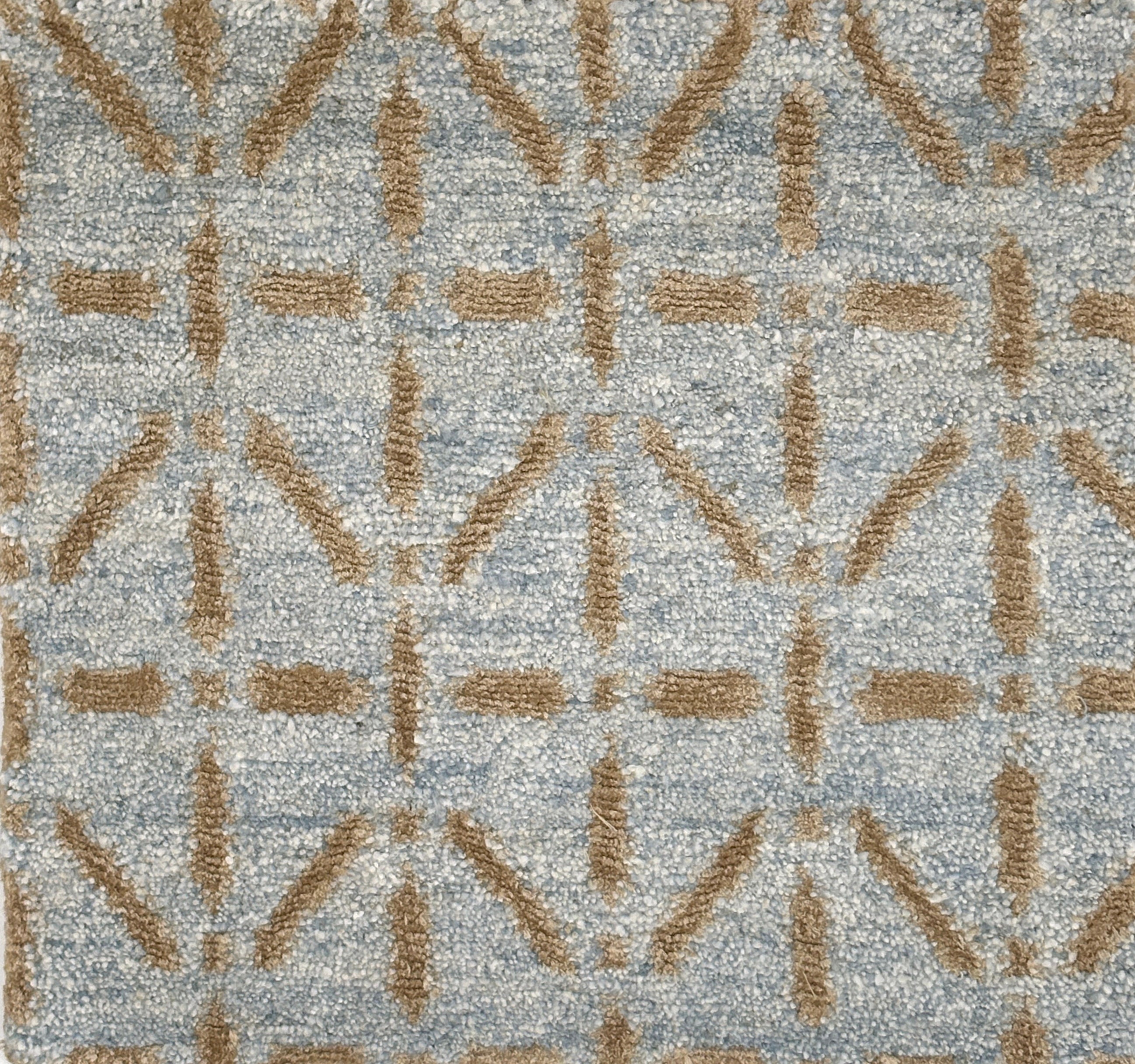 Handknotted rug with tan linear design on a light blue field. 