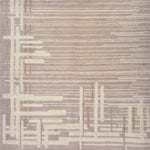 Detail of a contemporary rug with an taupe ground and a mix of thin lines and long slender rectangles in cream