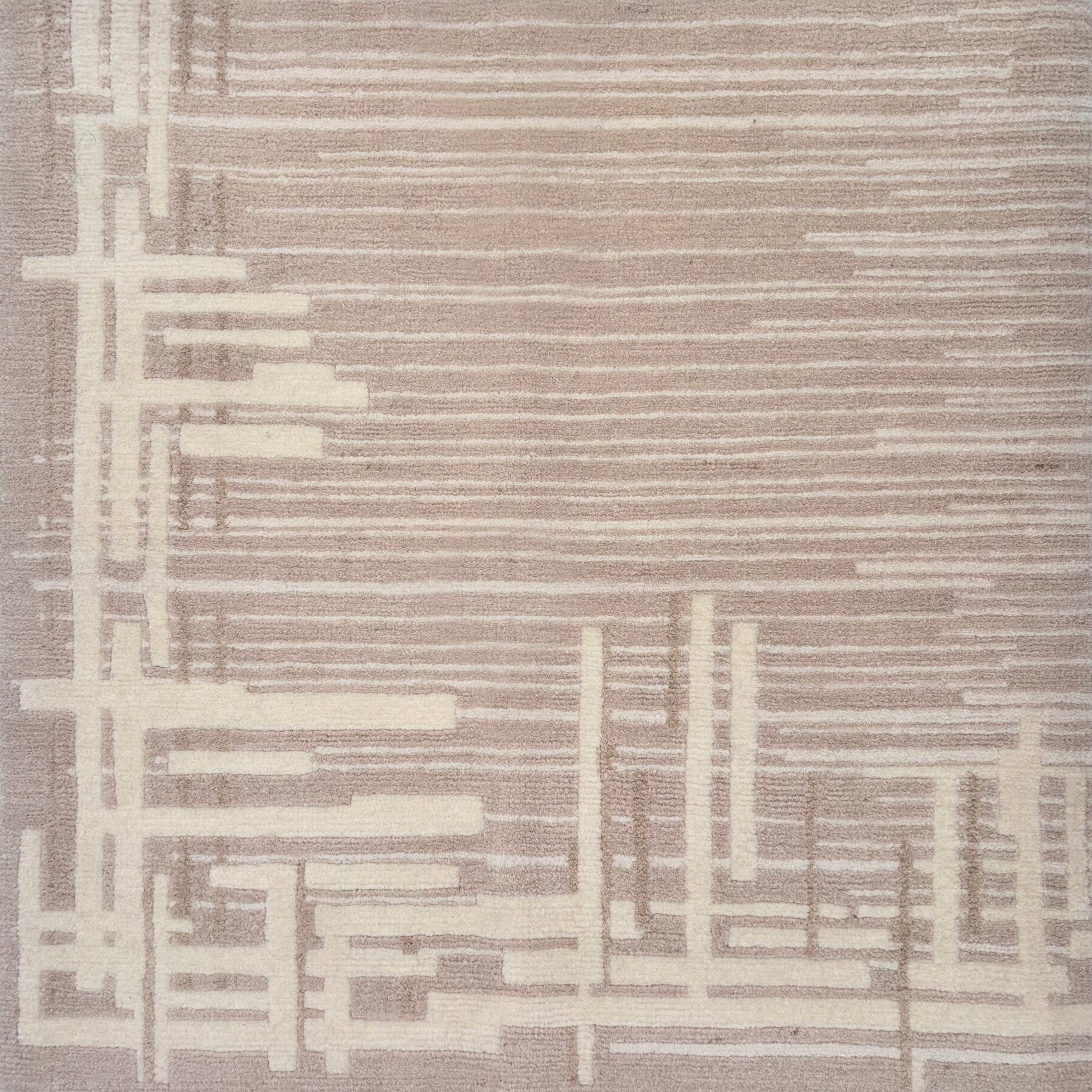 Detail of a contemporary rug with an taupe ground and a mix of thin lines and long slender rectangles in cream