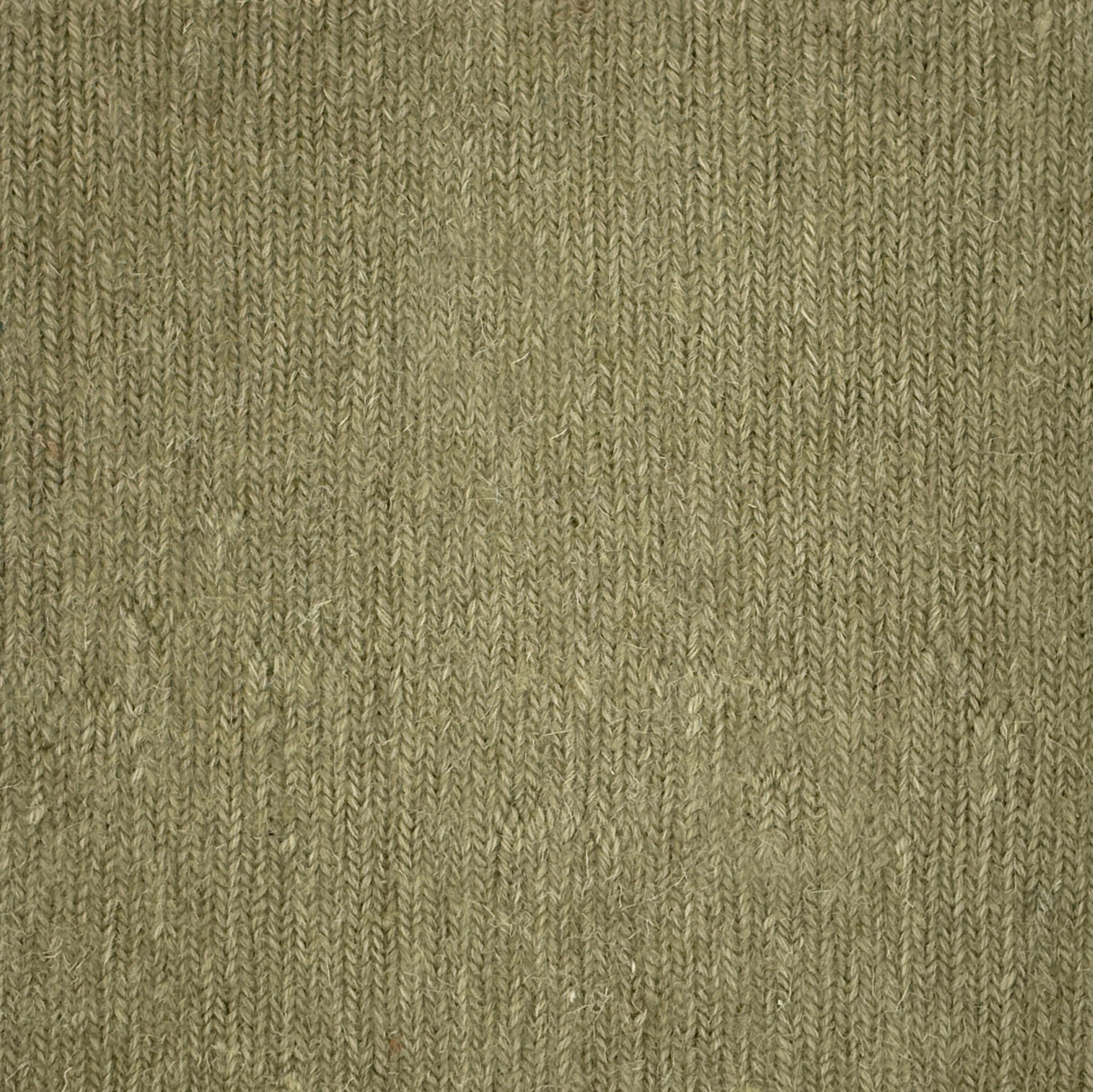 Close up of a carpet with a herringbone weave in sage green.
