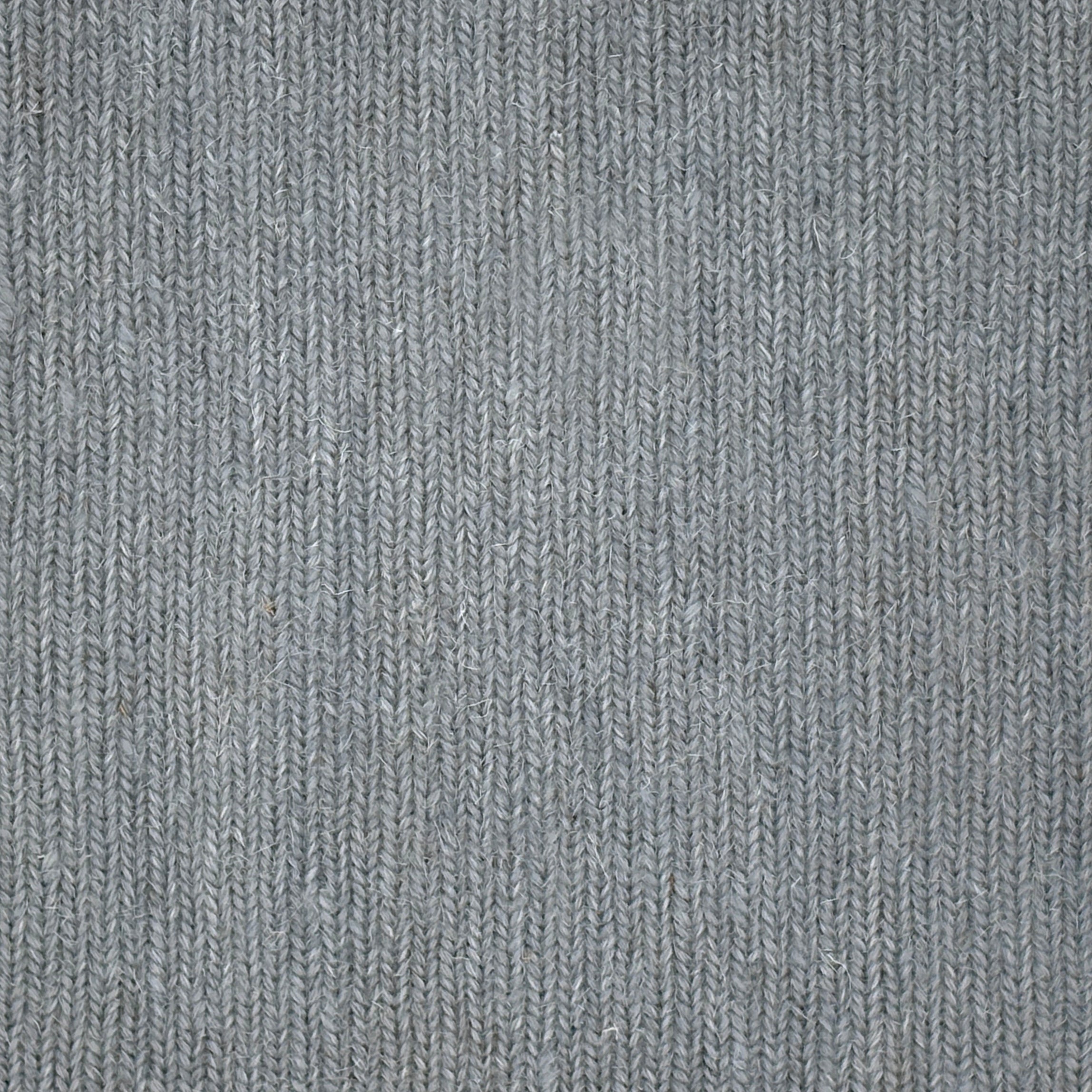 Close up of a carpet with a herringbone weave in light blue.