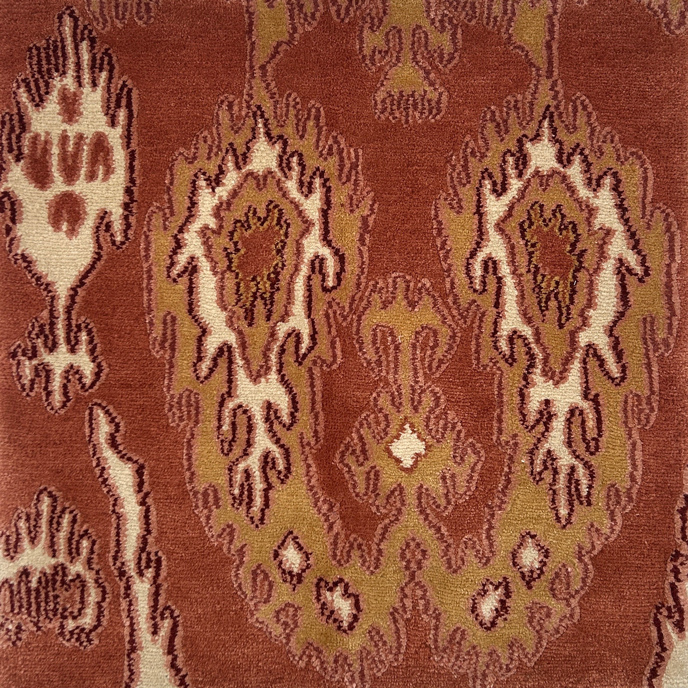 Close-up of a patterned rug with intricate ikat designs on a brown background