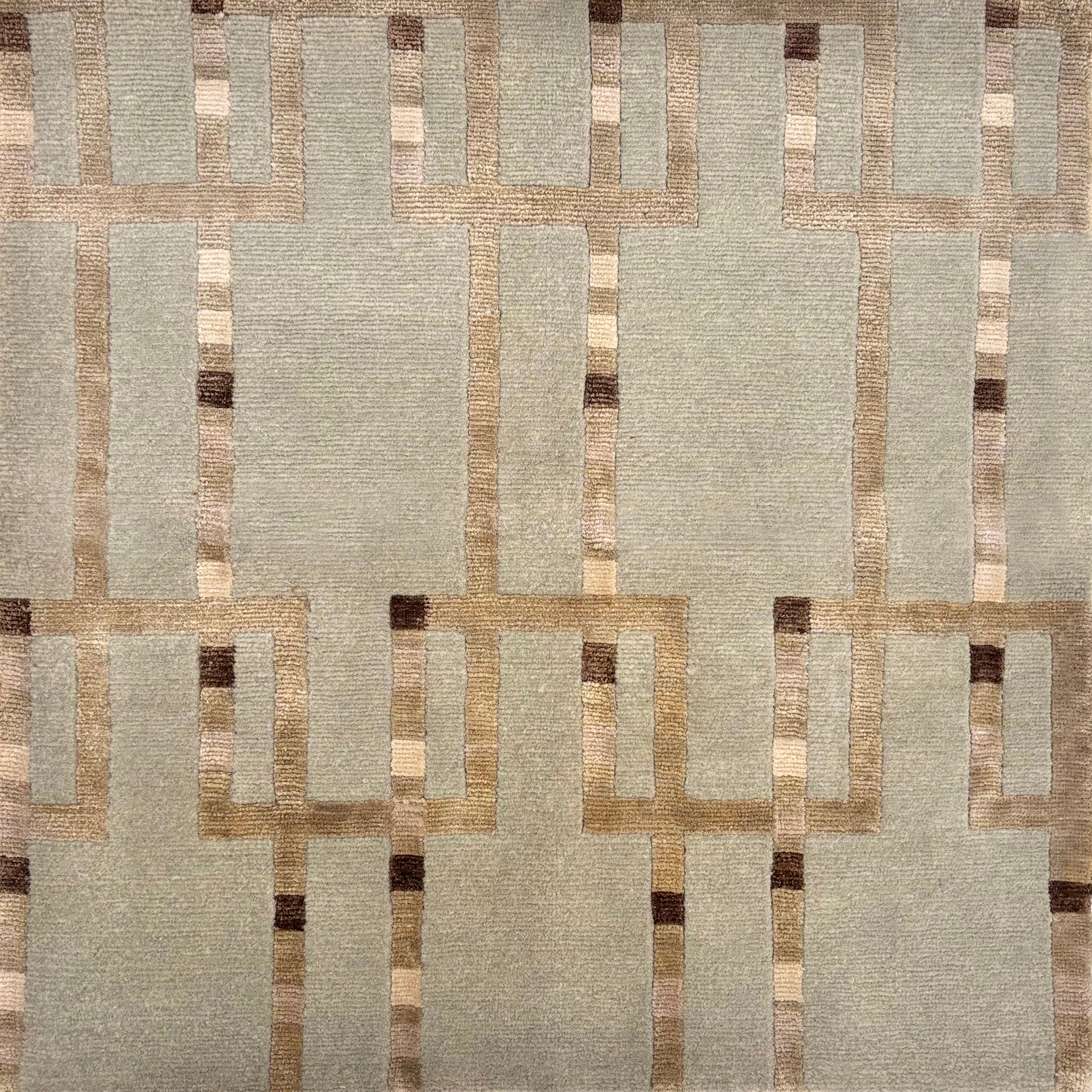 Handknotted rug sample in maze line rectalinear pattern in shades of brown on a soft green field. 