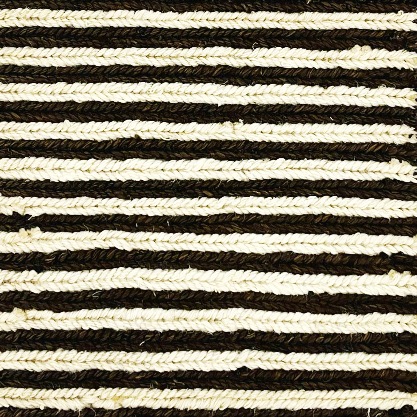 Woven rug swatch in natural fibers in a white and dark brown stripe pattern