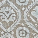 Close-up of fabric in a floral damask print in white on a light brown field.