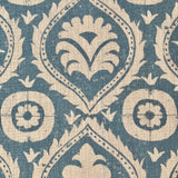 Close-up of fabric in a floral damask print in tan on a blue field.