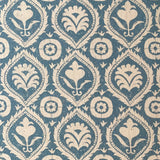 Detail of fabric in a floral damask print in tan on a blue field.