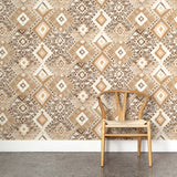 A wooden chair stands in front of a wall papered in a painterly diamond print in shades of brown, tan and white.