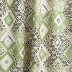 Draped fabric yardage in a painterly diamond print in shades of green, gray and white.